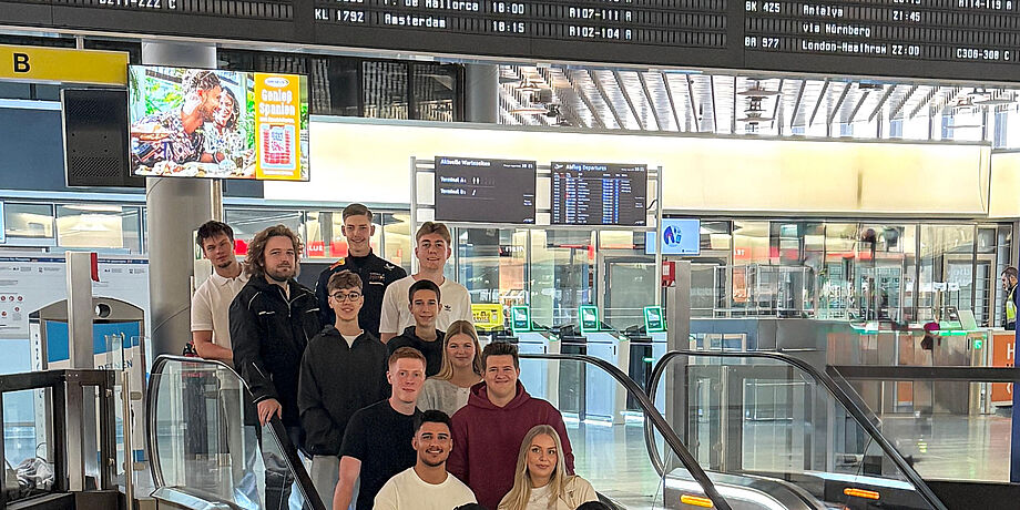 Die neuen Auszubildenden 2025 am HAJ auf einer Fahrtreppe im Terminal