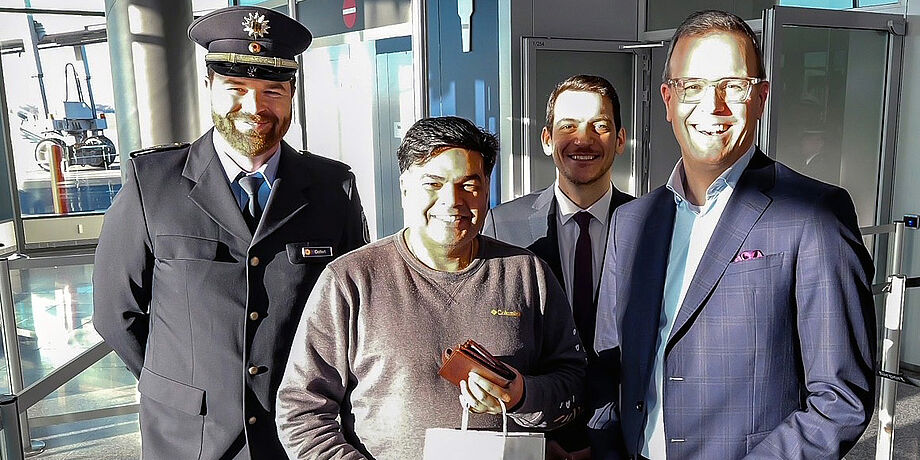 Drei Personen begrüßen den ersten EES-Fluggast.