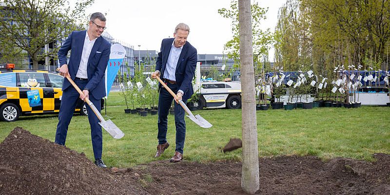 Foto der Geschäftsführer die symbolisch den Baum eingraben