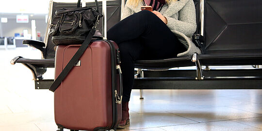 Frau mit Handgepäck im Terminal 