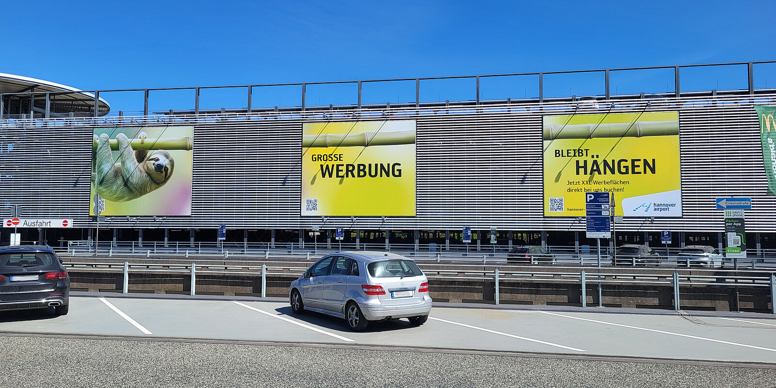Foto von drei Werbeplakaten am Parkhaus 1