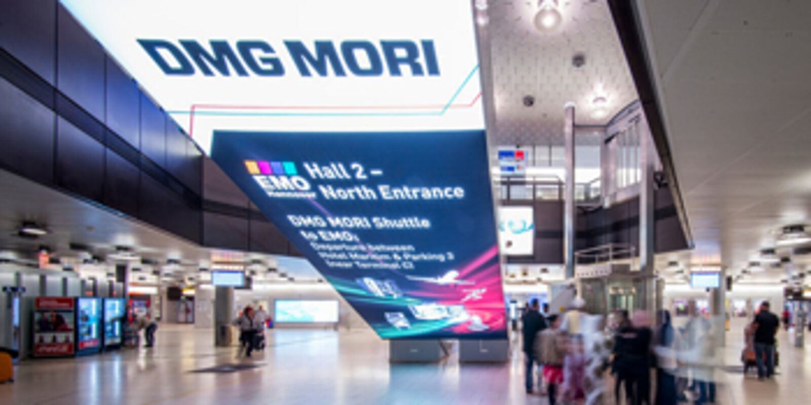 Musterfoto einer bespielten Werbefläche unterhalb einer Fahrtreppe im Terminal