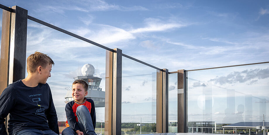 Zwei Kinder sitzen auf der Aussichtsterrasse