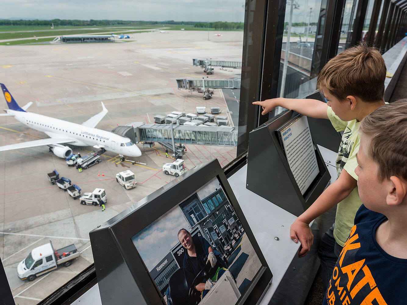 Zwei Jungen stehen auf der Aussichtsterrasse und schauen auf das Vorfeld
