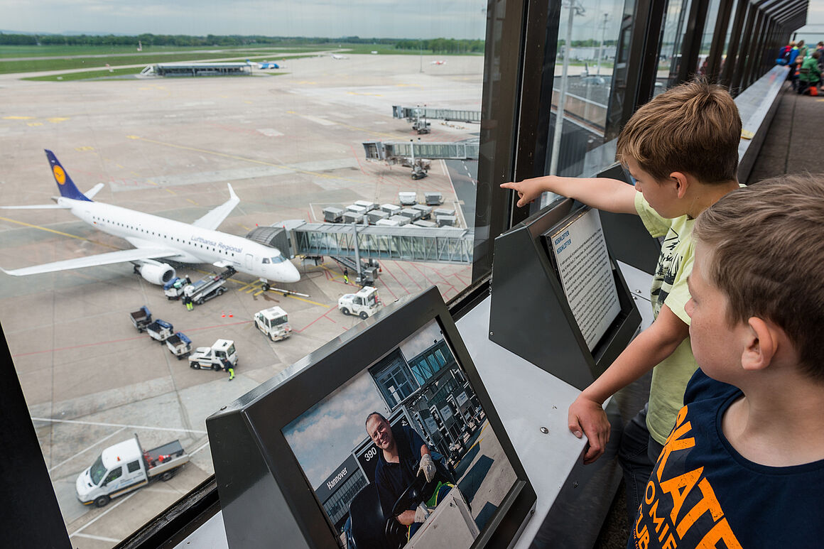 Zwei Jungen stehen auf der Aussichtsterrasse und schauen auf das Vorfeld
