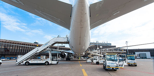 Vorfeldblick von hinten unter ein am Gate stehendem Flugzeug