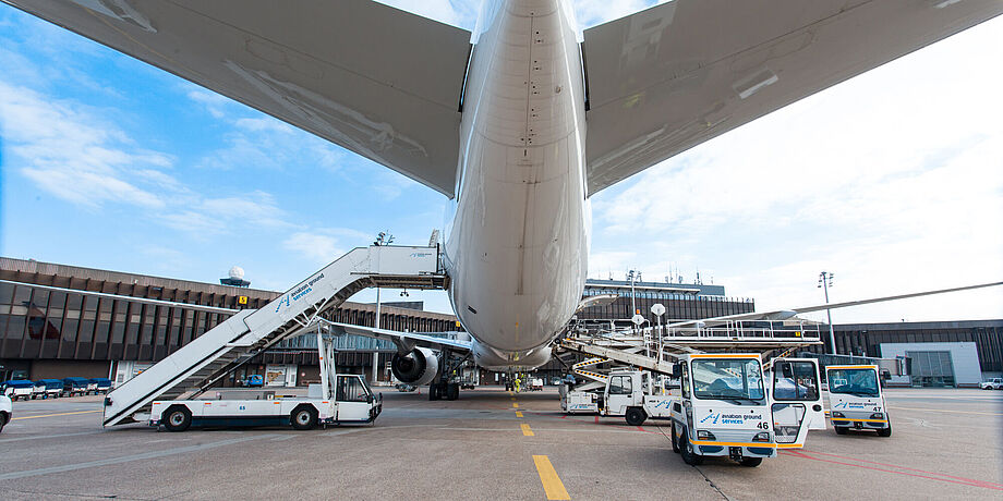 Vorfeldblick von hinten unter ein am Gate stehendem Flugzeug