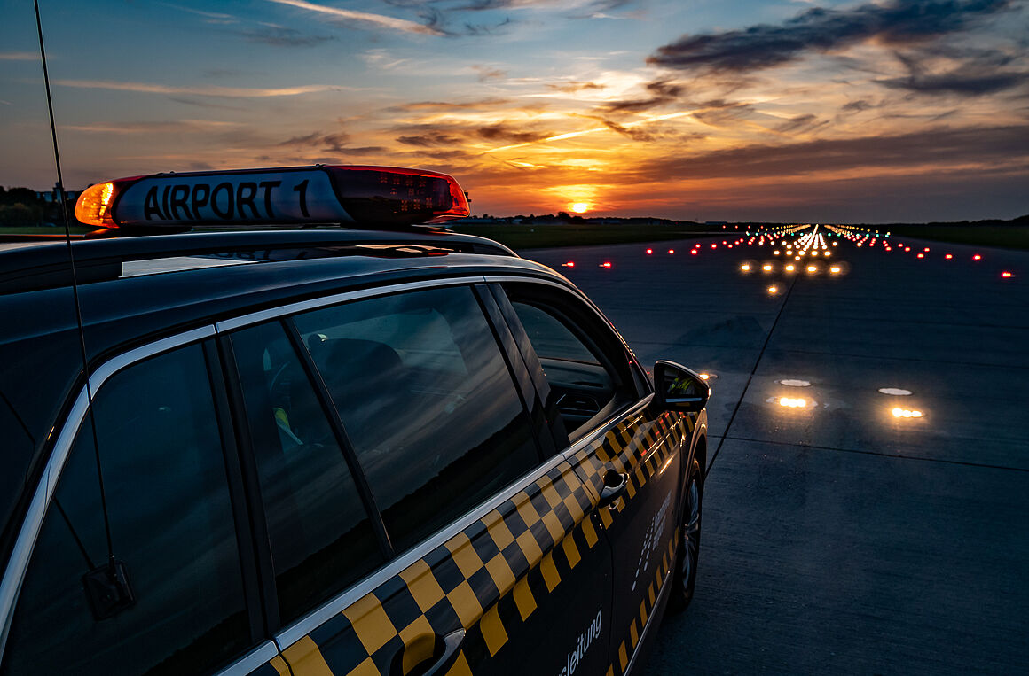 Foto eines Fahrzeuges auf der Landebahn im Dämmerlicht